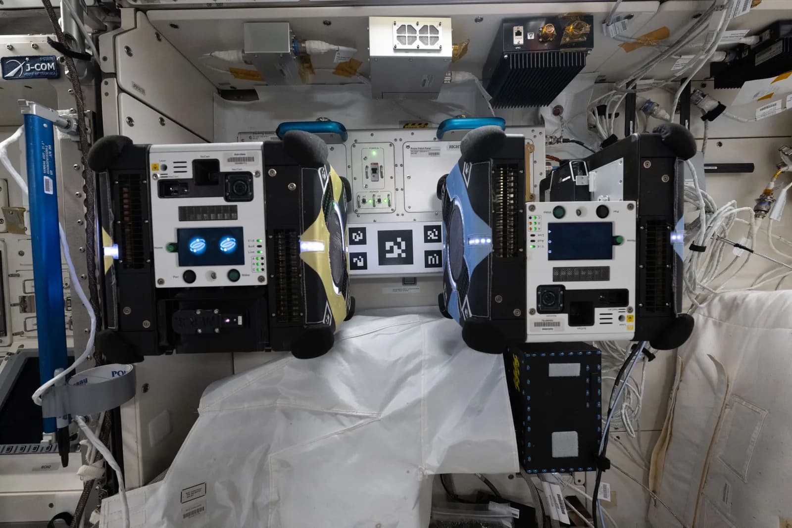 Dos robots Astrobee acoplados a su estación dentro de la Estación Espacial Internacional