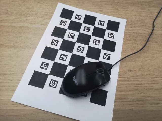 Tablero ChArUco impreso parcialmente cubierto por un ratón de computadora